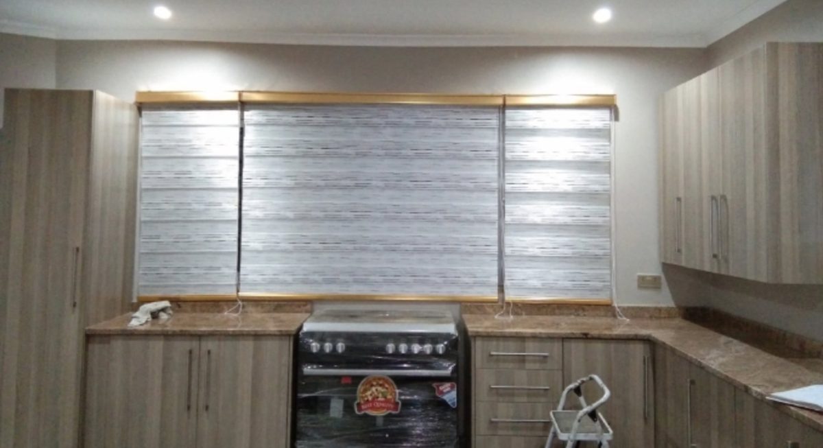 Day-and-night zebra blinds fitted across a kitchen window