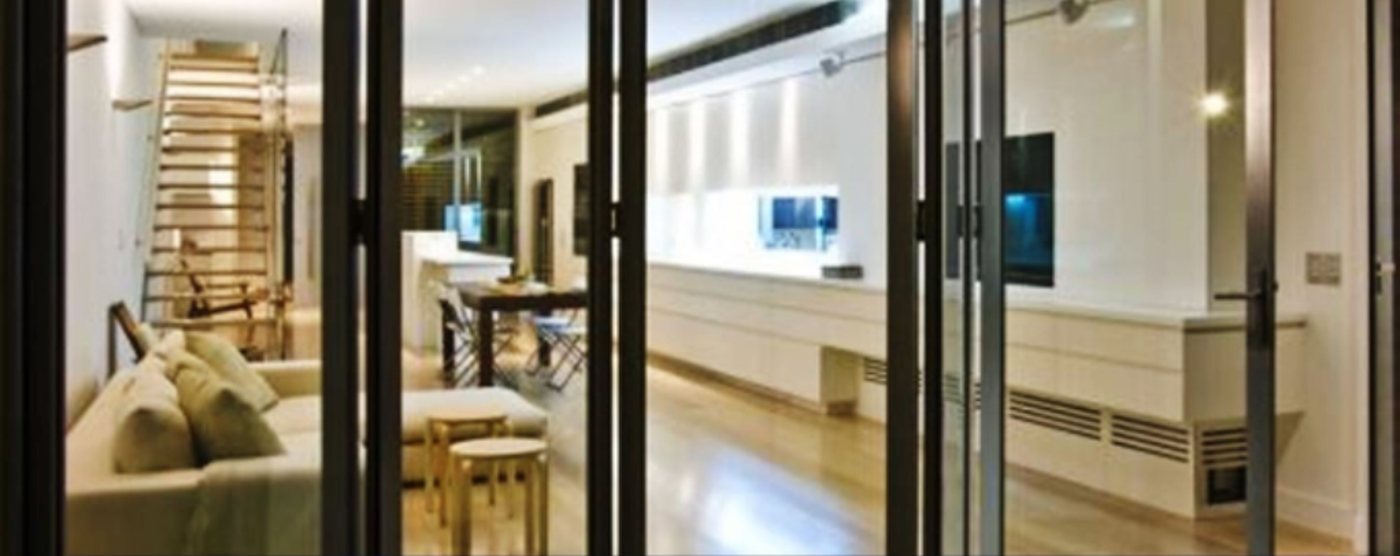 Aluminium folding sliding doors opening a living room onto the rest of the house
