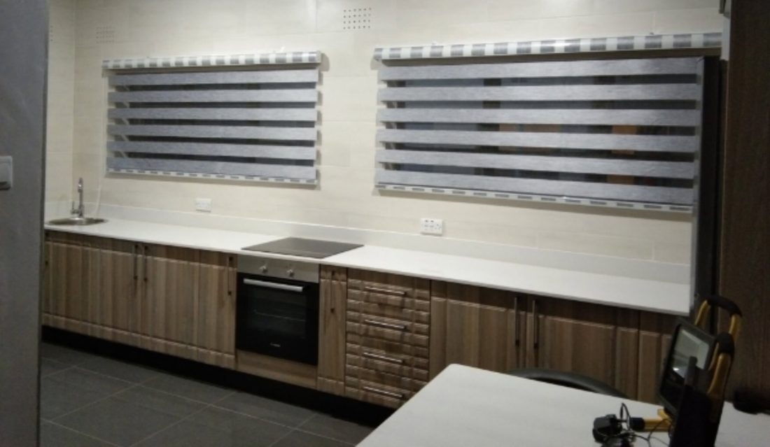 Day-and-night blinds fitted above a fitted kitchen